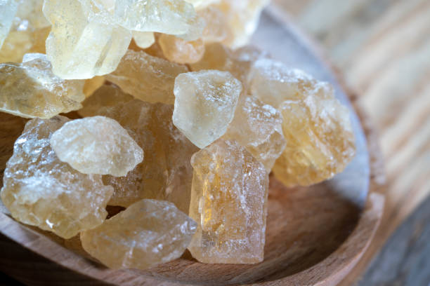 grande cristal de cana-de-açúcar mascavo sobre mesa de madeira - rock sugar - fotografias e filmes do acervo