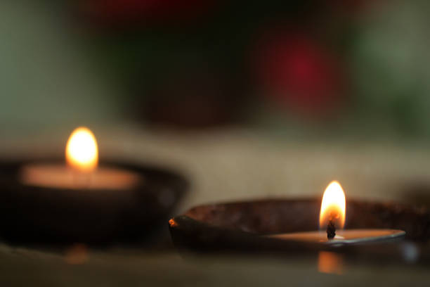 Burning candle in the dark. Candles  light in traditional bowl ceramic. Praying with candle light in the night. Faith love and hope concept. Candles light background.