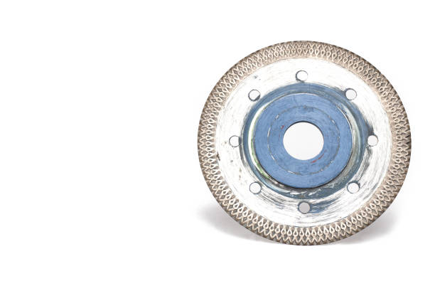 Close up of heavily used shiny silver metal and blue special carbide cutting disc for cutting tiles and stone slabs for use in angle grinder when laying tiles on white background