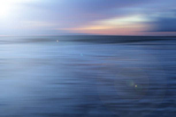 istock Sea at sunset with white smooth wave motion cover the black sand. 1389072168