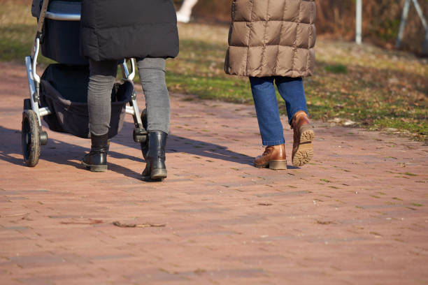 istock 2 women with strollers. People with warm clothes. Rear view. 1389074111