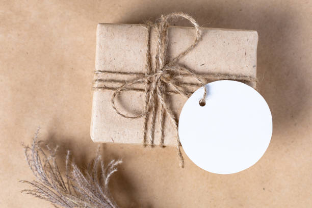 istock empty white gift tag mock up on craft paper box with dried spikelets decoration on natural beige background. 1389079343