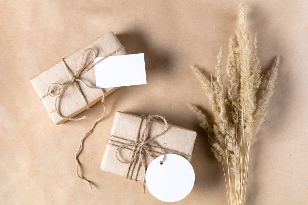 istock empty white gift tag mock up on craft paper box with dried spikelets decoration on natural beige background. 1389079344