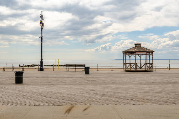 istock Empty Beach Promenade with Pavilion at Coney Island during sunset with ocean and cloudy Sky, NYC 1389079449