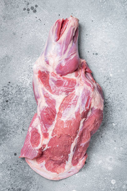 istock Raw lamb shoulder meat on butcher table. Gray background. Top view 1389081066