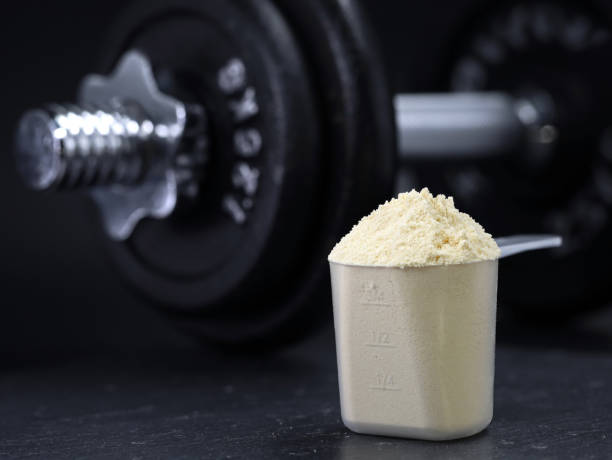 istock whey protein powder in scoop with dumbbell on black background 1389082527