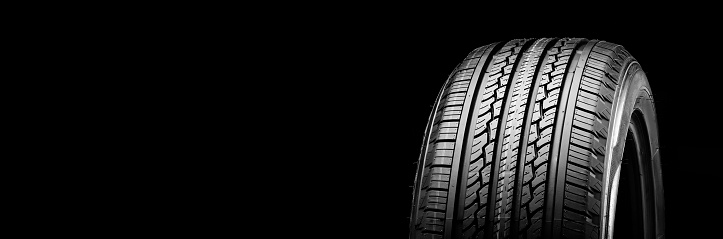 all-season new tire on a black background kopi space panorama auto parts.