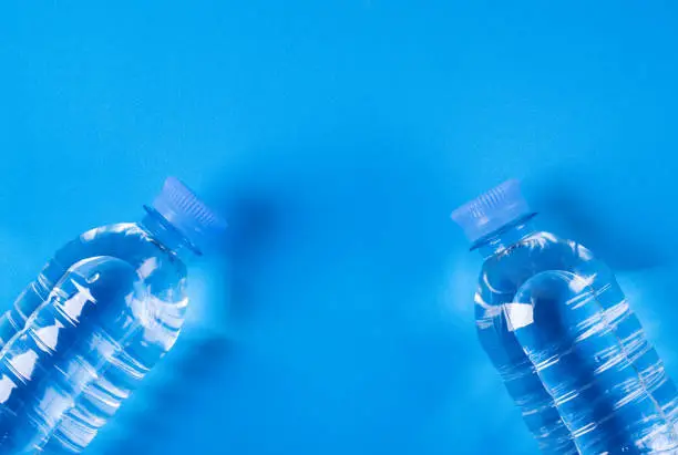 Photo of Two bottles of clean drinking water on blue