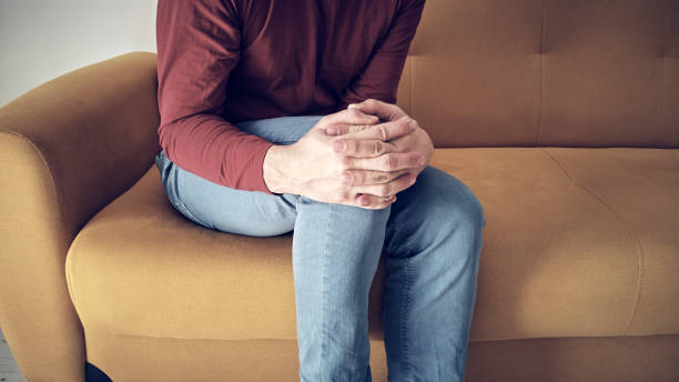 istock Man with injured knee at home. 1389093459