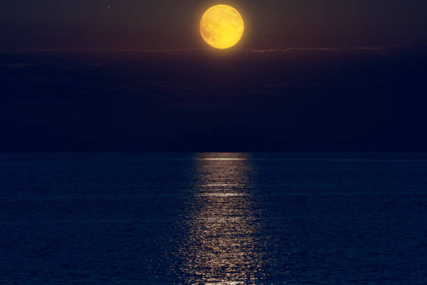 istock Moon with starry skies above ocean horizon. 1389093514