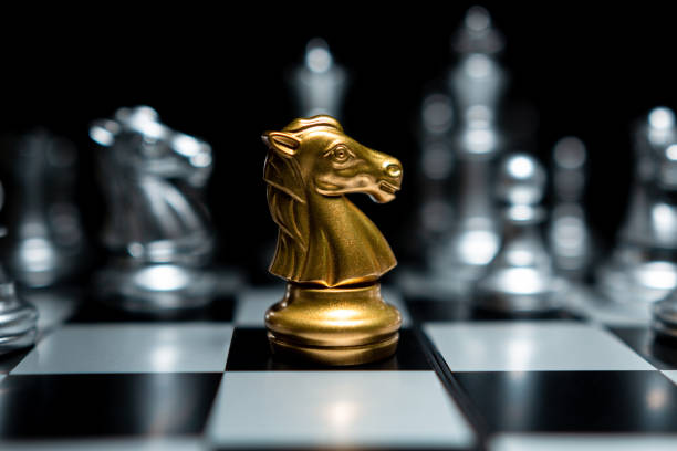istock Golden knight chess surrounded by chess pieces 1389095003
