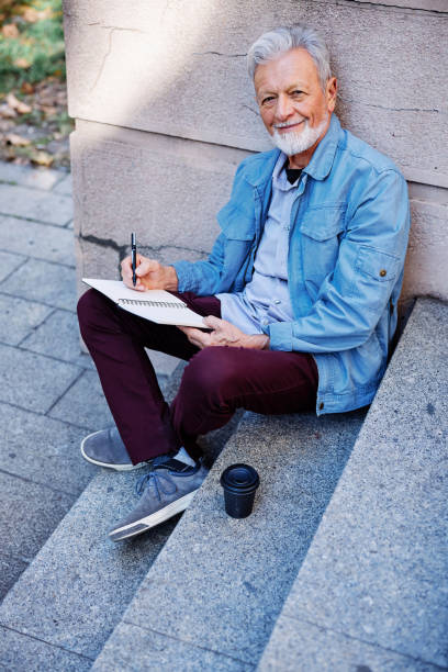 istock A senior man sitting outside and writing to do list. 1389096343
