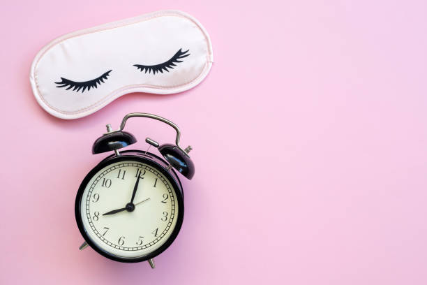 istock Healthy sleep concept with mask, alarm on black 1389100250