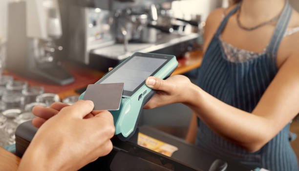istock Shot of a customer using a nfc machine to make a card payment at a restaurant 1389103355