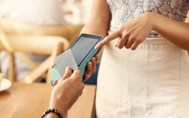 istock Shot of a customer using a nfc machine to make a card payment at a restaurant 1389103360