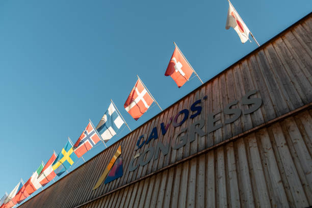 Waving flags at the congress center in Davos in Switzerland Davos, Switzerland, March 23, 2022 Different national flags are waving over the entrance to the congress center building on a sunny day graubunden canton photos stock pictures, royalty-free photos & images