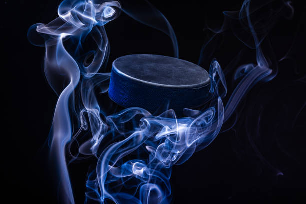 An abstract view of an ice hockey puck flying across a smoke installation. stock photo