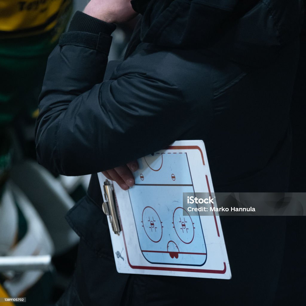 Ice hockey coach holding a flip chart while watching the game Helsinki / Finland - MARCH 22, 2022: Ice hockey coach holding a flip chart while watching the game Hockey Stock Photo