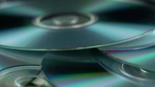 CD Disks On Pile Against Black