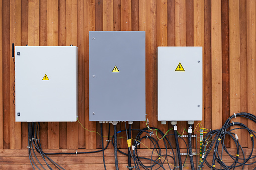 Electric meters and equipment cabinets on facade of wooden house installation
