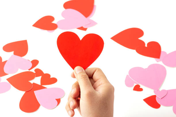 istock Hand holding a red heart shaped paper craft isolated on a white background. 1389107984