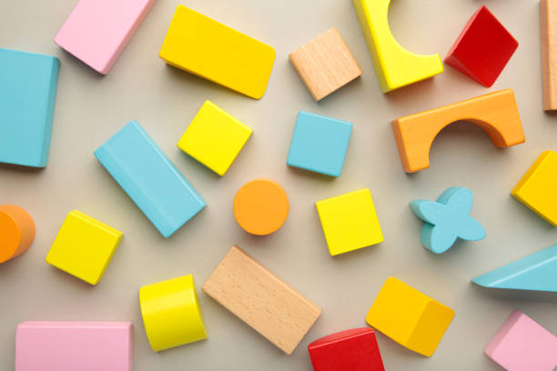 istock Multicolored blocks of the children's constructor lie on grey background. 1389111118