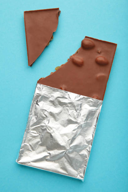 istock Bitten Chocolate bar in foil on blue background. With clipping path 1389111774