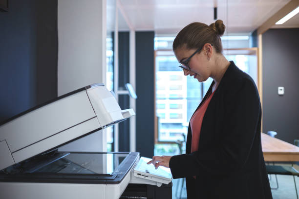 istock Smiling businesswoman using scanner in office 1389113282