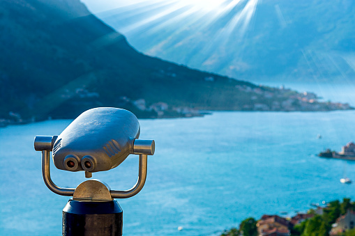 Close-up of binoculars for tourists in selective focus, overlooking Grenoble city. This image was taken during a cloudy summer day, in the department of Isere, Auvergne-Rhône-Alpes region in France, Europe.