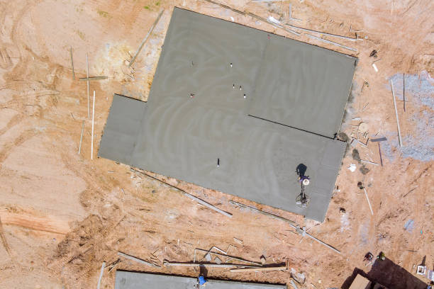 istock Aerial view of construction worker using machine application grinding cement screed foundation on new house complex 1389116430
