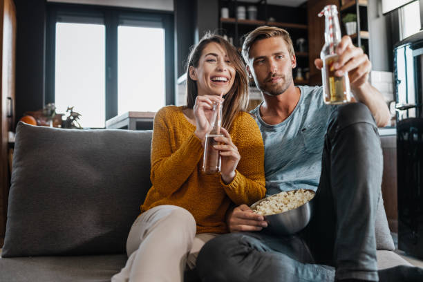 istock Young couple relaxing at home and watching TV 1389116505