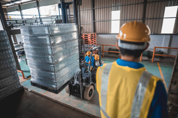 istock Asian warehouse worker loading cartons in pallet on truck with forklift while foreperson counting stock 1389120417