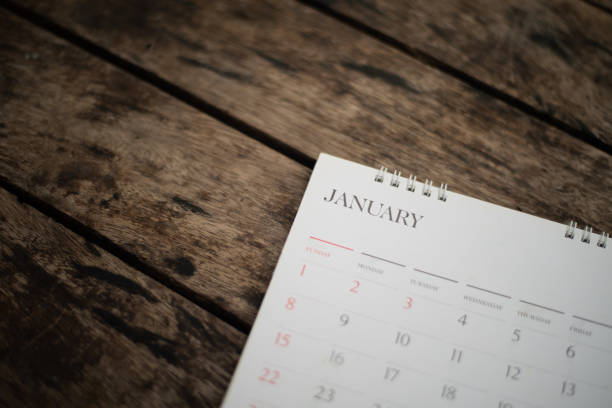 istock Blurred white calendar on wood texture. 1389122056