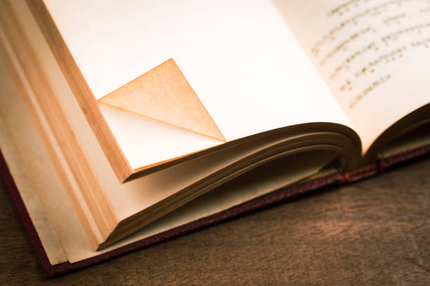 Folded corner of the current page (dog ear) as a bookmark in the paperback antique book