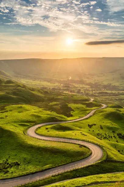 Photo of Long Winding Rural Road Leading To Beautiful Sunset. Peak District, UK.