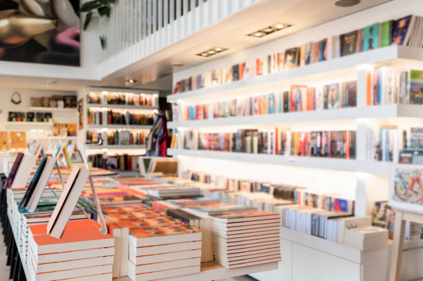Bookstore full of books makes for better everyday life Very modern and bright bookstore with white shelves full of books seen during day light. book display stock pictures, royalty-free photos & images