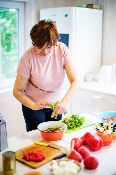 istock Active senior woman cooking vegetables at home 1389126324
