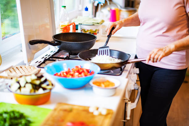 istock Active senior woman cooking vegetables at home 1389126353