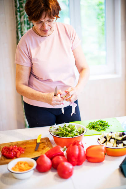 istock Active senior woman cooking vegetables at home 1389126357