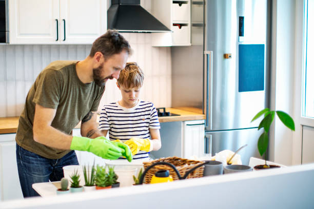 istock Father teaching son to pot houseplant 1389127032