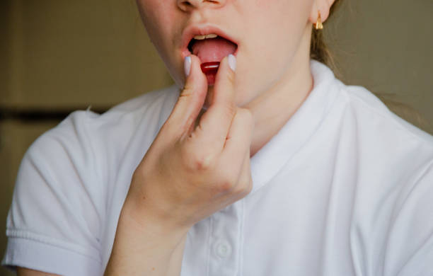 istock the girl drinks a red pill. close-up photo 1389130621