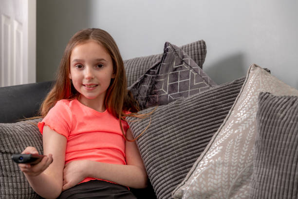 istock Girl uses TV remote control 1389134063