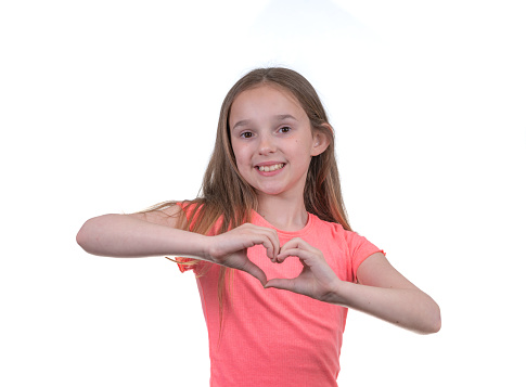 Young girl making heart shape with hands