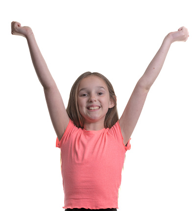 Happy girl holds up her arms in a winning pose