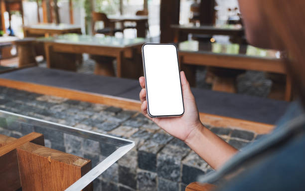 istock Mockup image of hands holding black mobile phone with blank desktop screen 1389134891