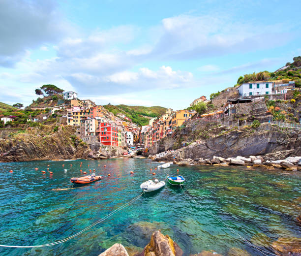 incrível paisagem urbana com barcos e casas coloridas em riomaggiore, cinque terre, itália. lugares incríveis. um lugar de férias popular. - cinqueterre - fotografias e filmes do acervo