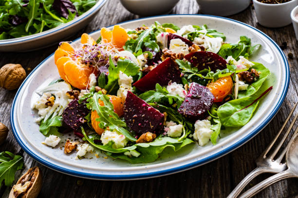 Beetroot salad with goat cheese on wooden background stock photo