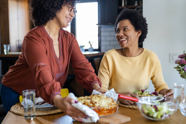 istock Two mid adult women having dinner at home 1389141307