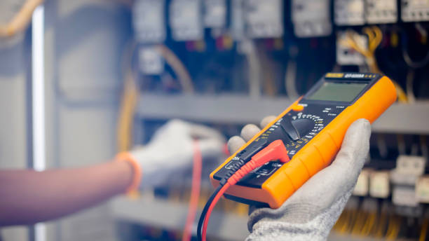 un ingénieur électricien utilise un multimètre pour tester l’installation électrique et le courant de la ligne électrique dans une armoire de commande de système électrique. - electricity industry factory control panel photos et images de collection