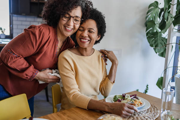 Portrait of lesbian couple at home Two lesbian women having good time together during dinner. lesbian couple embracing stock pictures, royalty-free photos & images